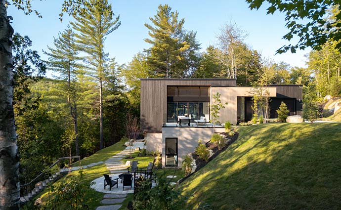Situé à Saint-Hippolyte, au cœur d’un paysage naturel marqué par la forte pente du terrain et la beauté du lac Fournelle, L’Intervalle est un projet architectural résidentiel qui fait dialoguer subtilement nature et construction. Penchant pour une esthétique contemporaine, ce chalet conçu par l’atelier BOOM-TOWN réinterprète la villégiature québécoise en harmonie avec son environnement, offrant une expérience unique d’habitat où chaque espace invite à la contemplation et à la sérénité.