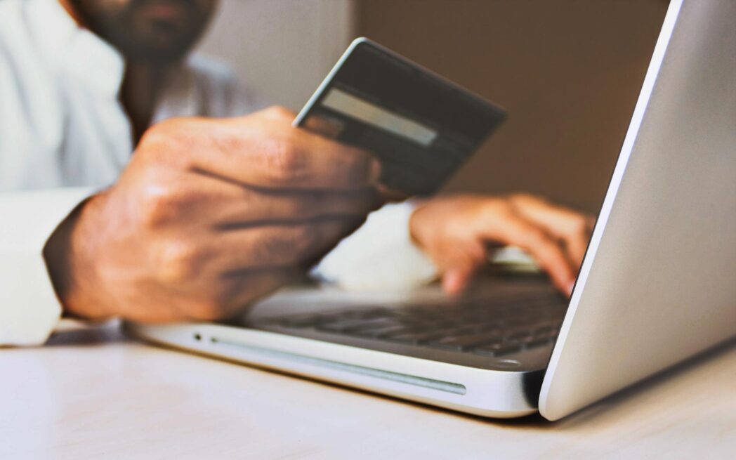 person with a credit card using a computer – WestmountMag.ca